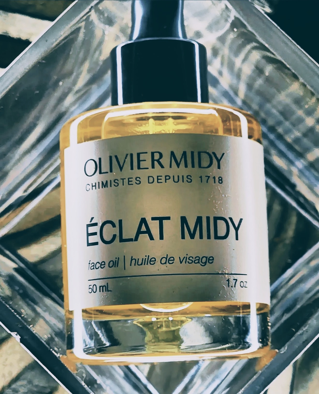 Olivier Midy Éclat Midy golden face oil bottle on cut crystal glass