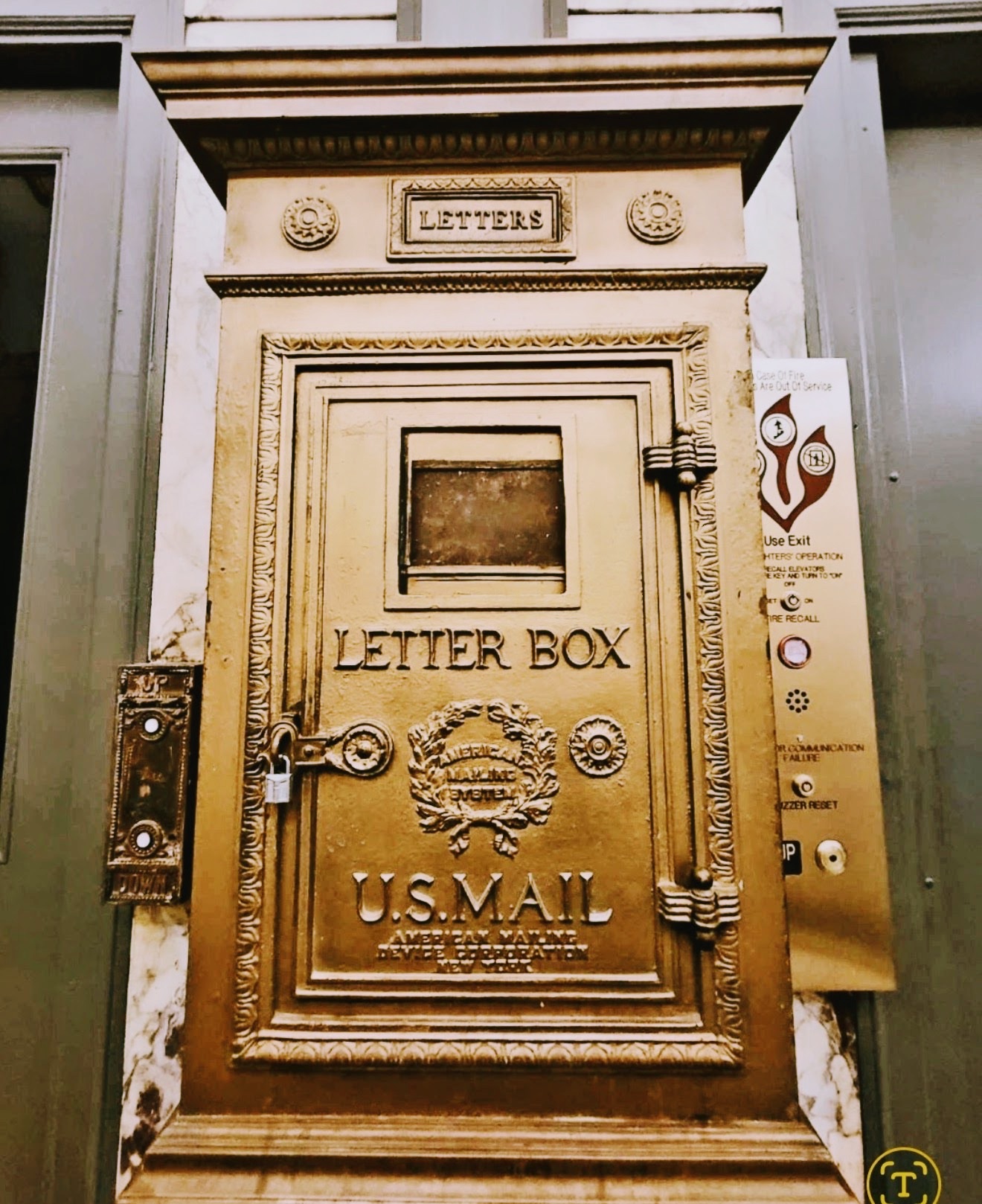 Ornate brass U.S. Mail letter box in a marble lobby