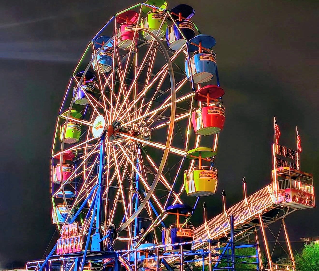 Ferris wheel lit in every colour against a black night sky