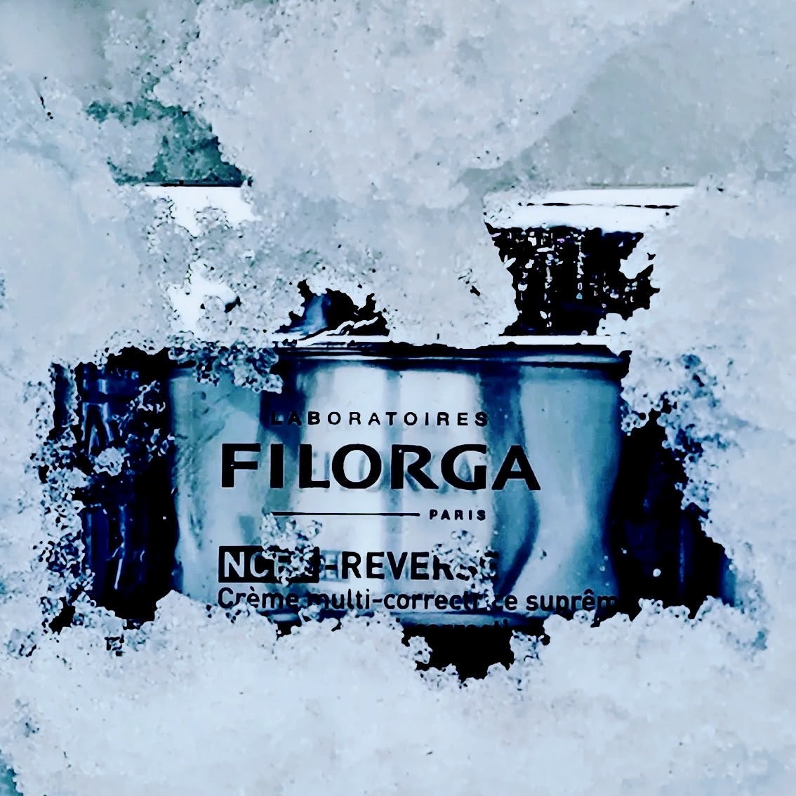 Filorga NCEF-Reverse cream jar half buried in snow