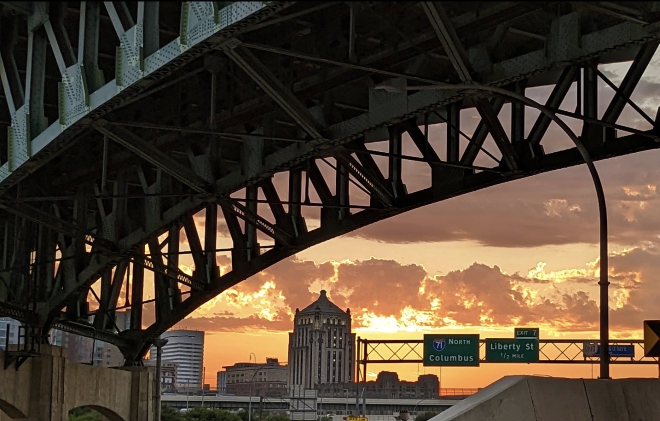Silhouetted bridge arch over a burning orange sunset