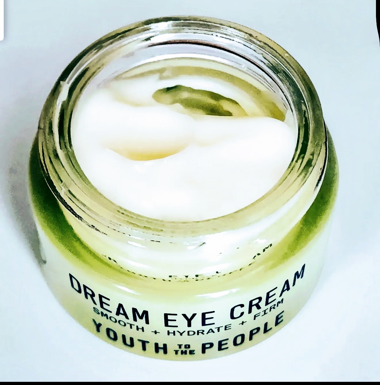 Open jar of Youth to the People Dream Eye Cream showing swirled cream inside