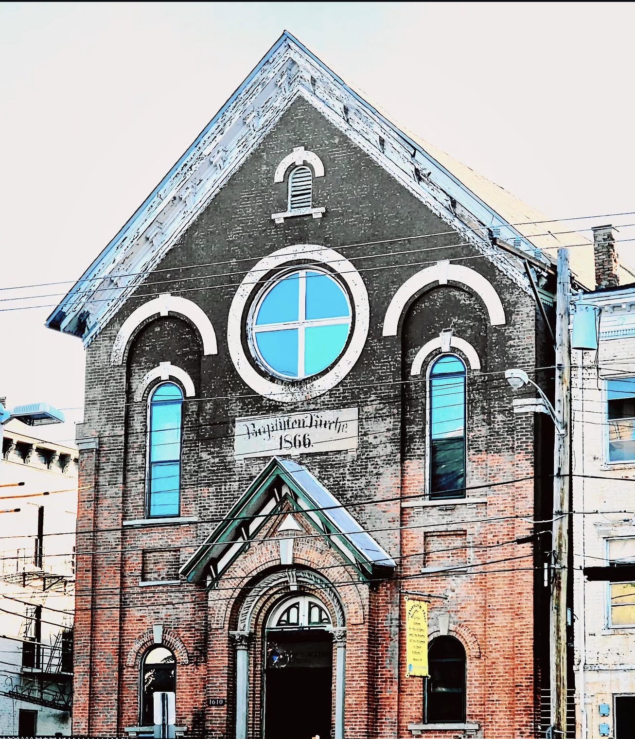 Old brick Baptist church from 1866 with a bright blue rose window