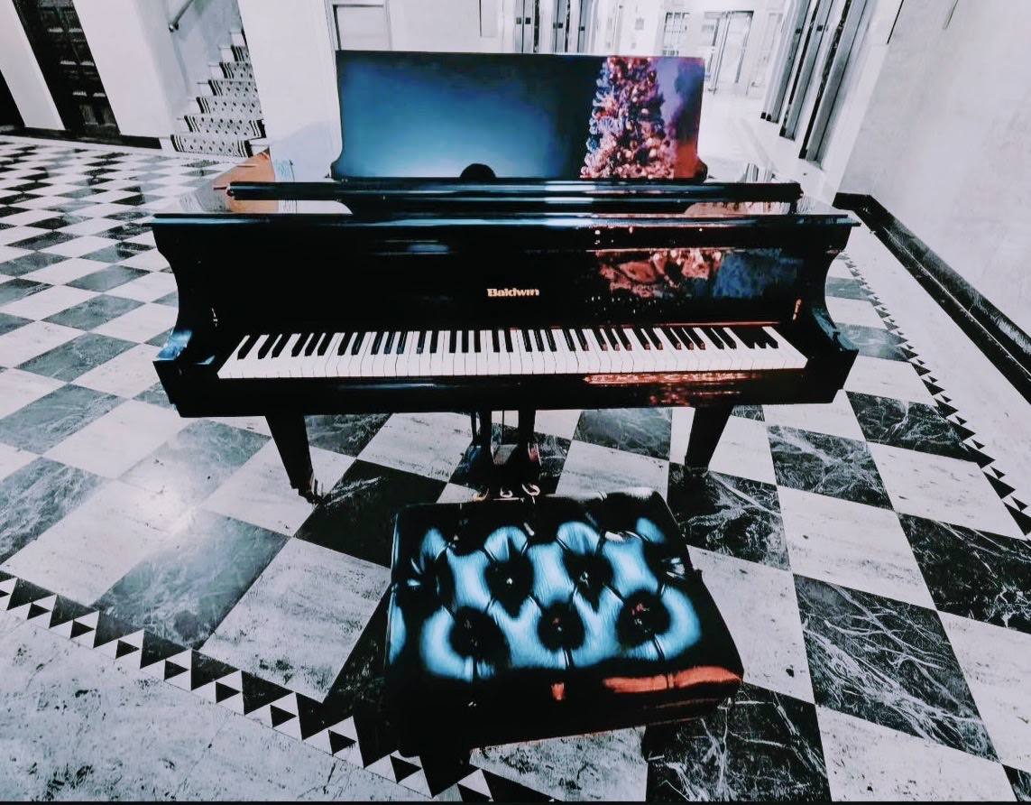 Black grand piano on a checkerboard marble floor